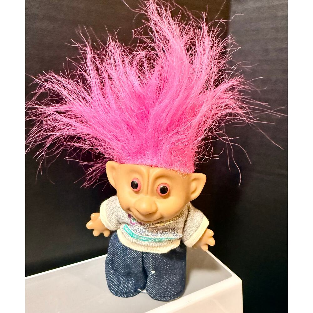 1990’s Troll doll pink hair wearing an Ameriflora '92" international floral